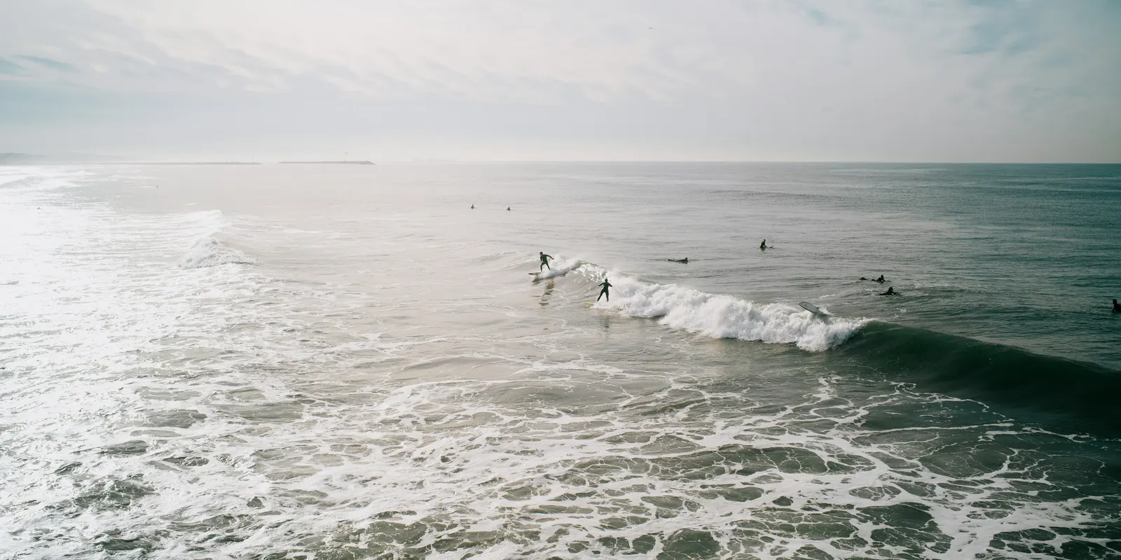 Surfers catching waves on a coastal break.