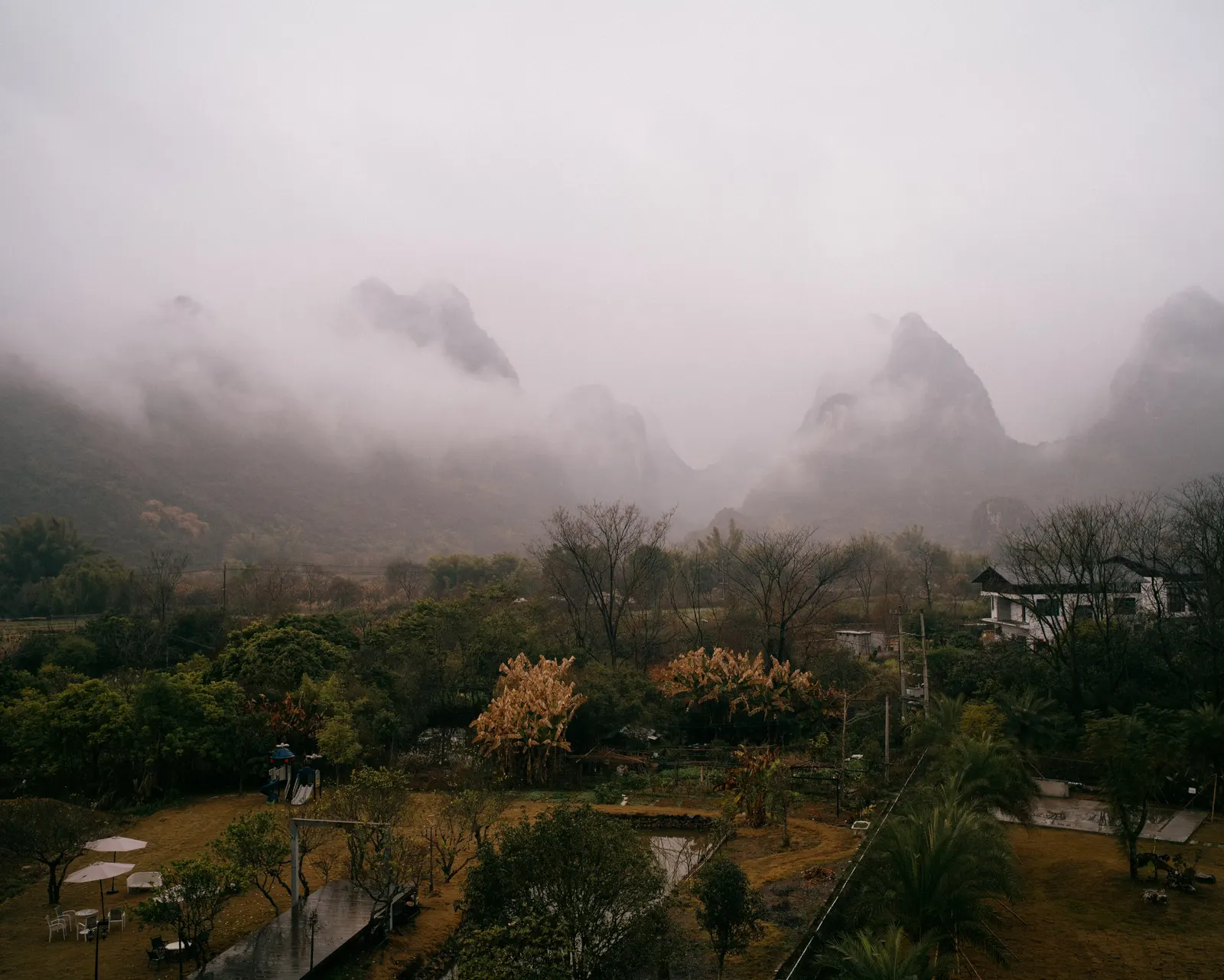 Mountains emerge through fog and mist in the valley below.