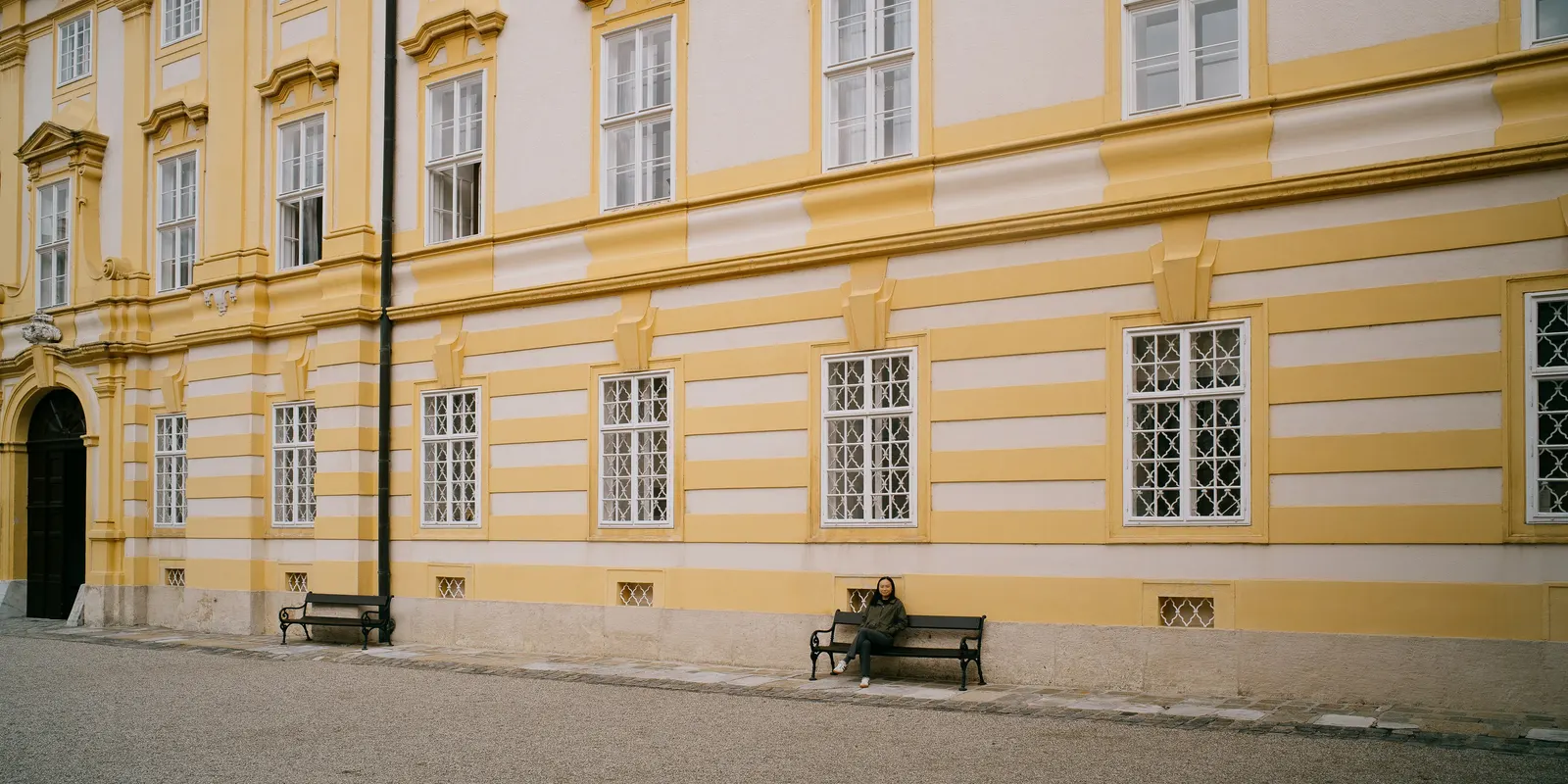 The abbey's yellow facade and its empty benches.
