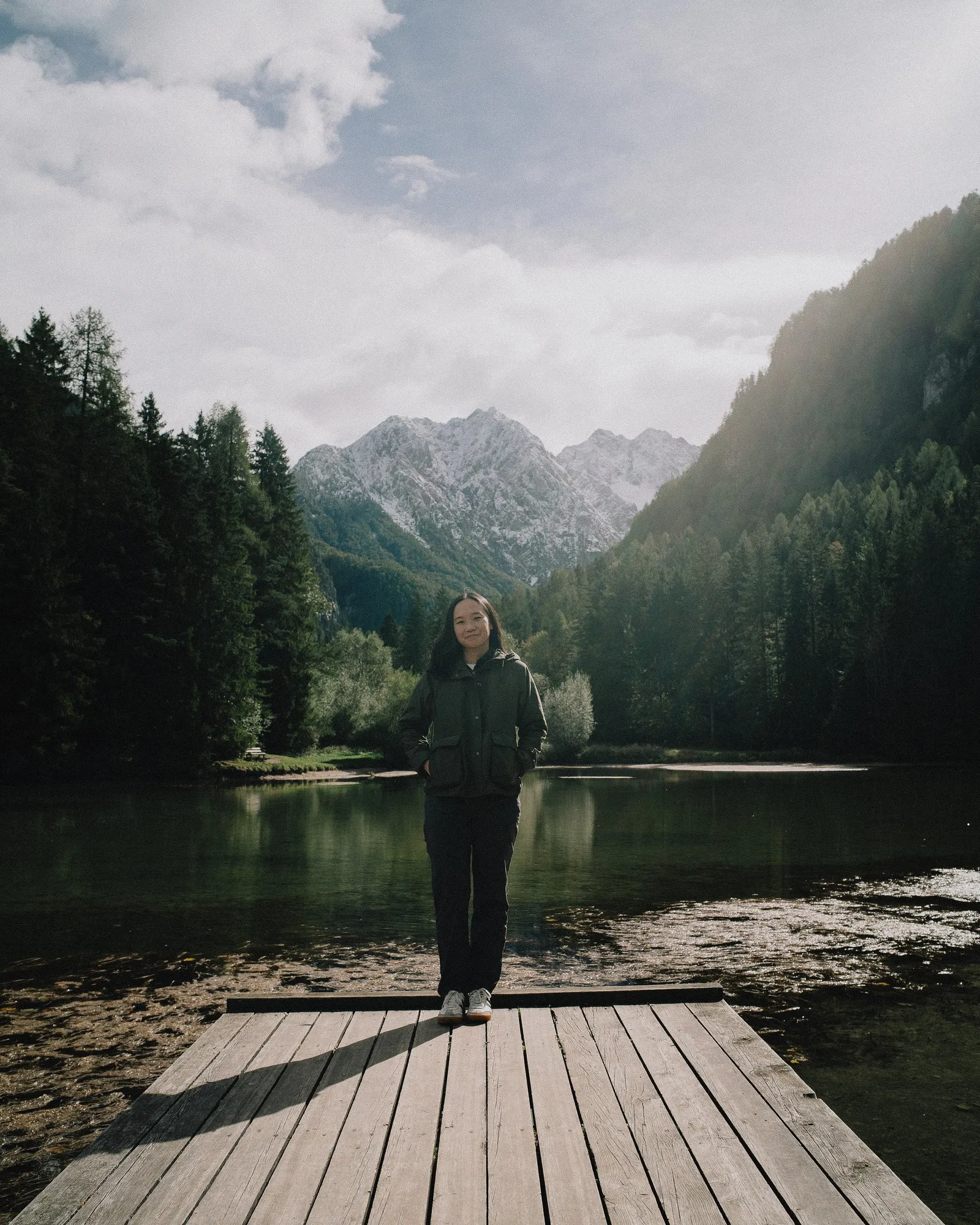 A figure alone on the jetty, the mountains behind.