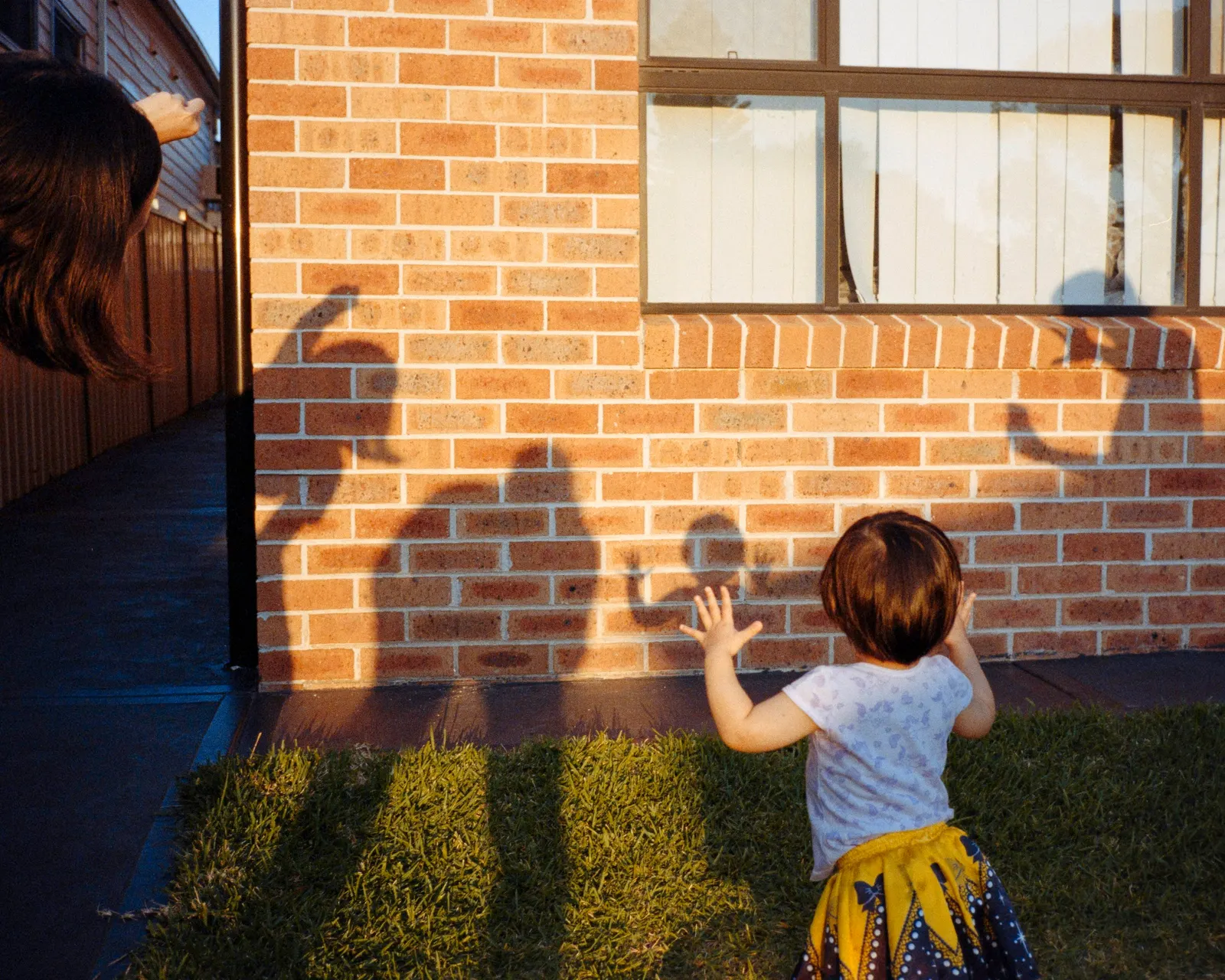 A child reaching for the light at the window.