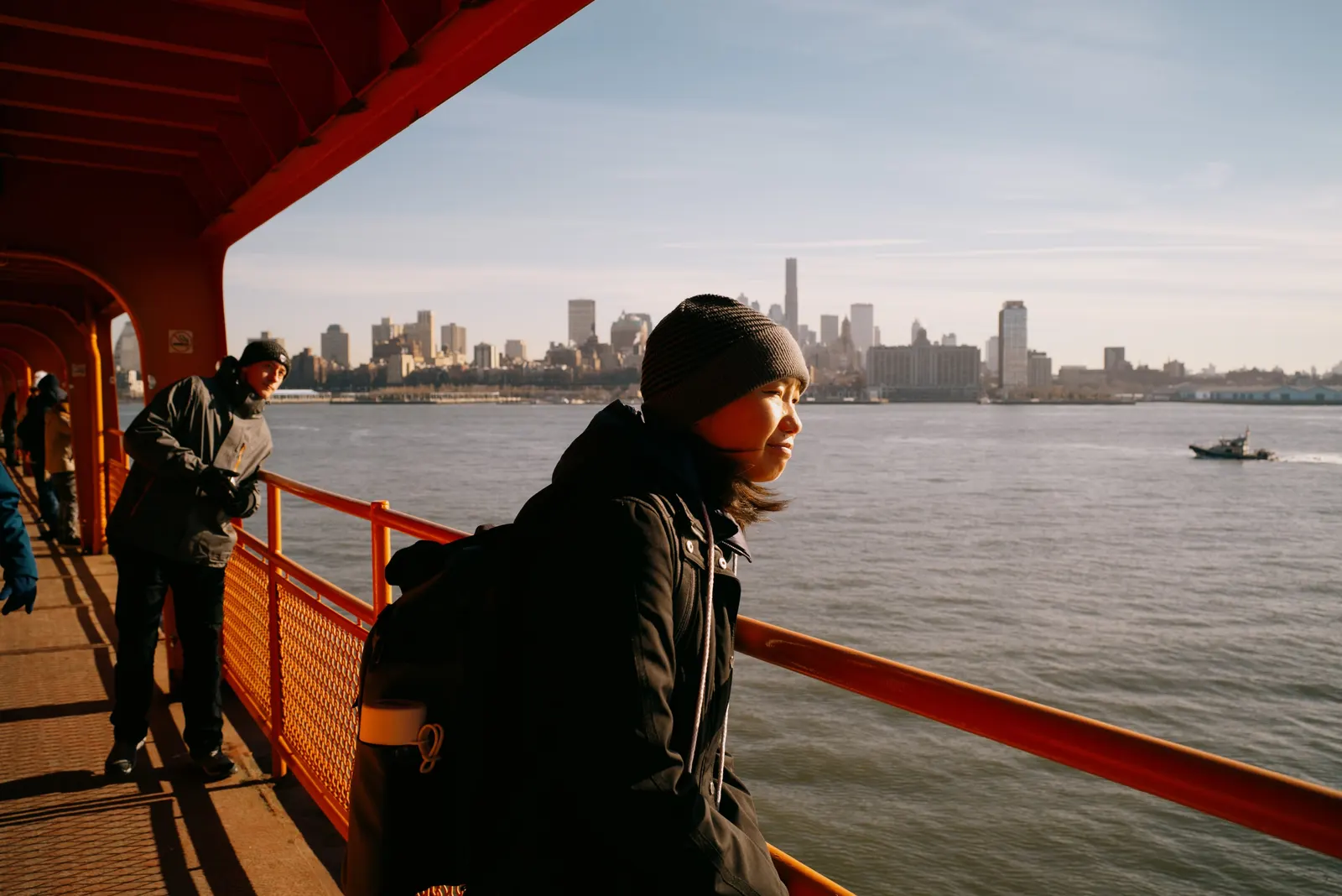 Leaning on the rail, watching the water.